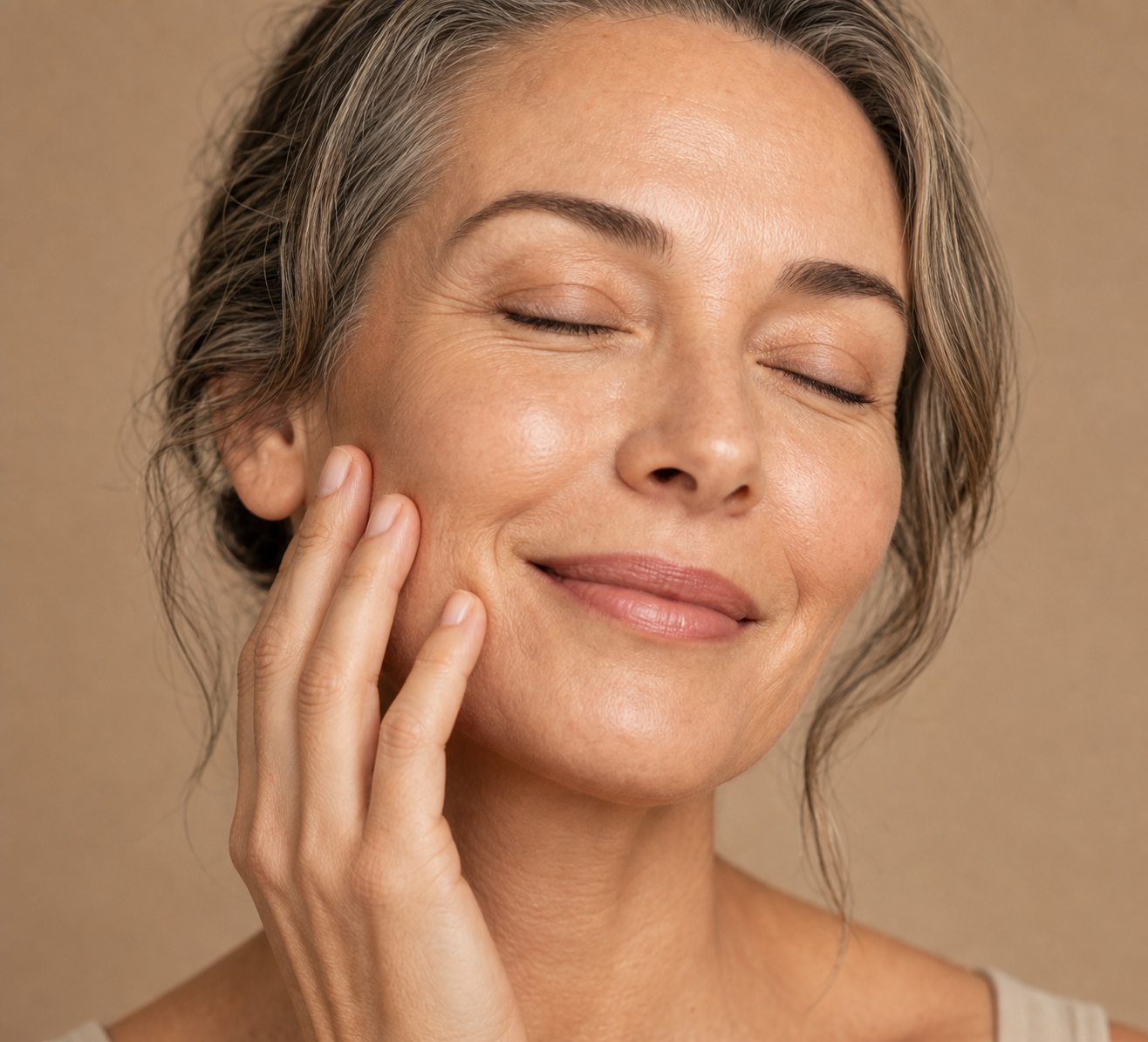 Adult smiling against a beige background