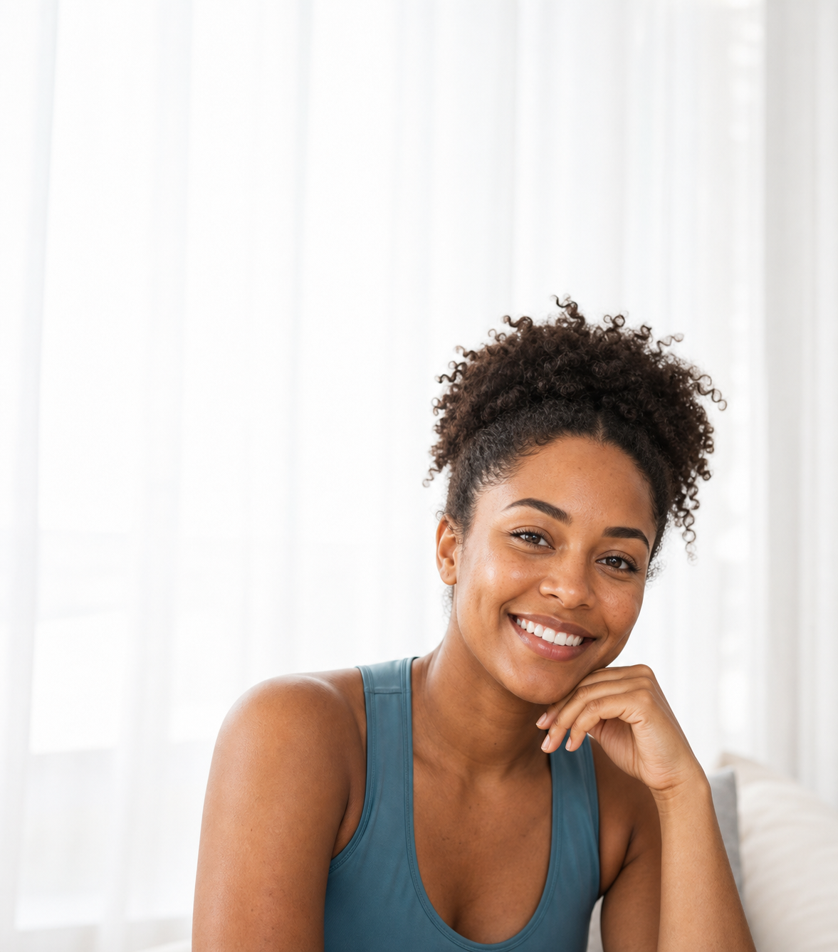 Adult smiling beside bright curtains