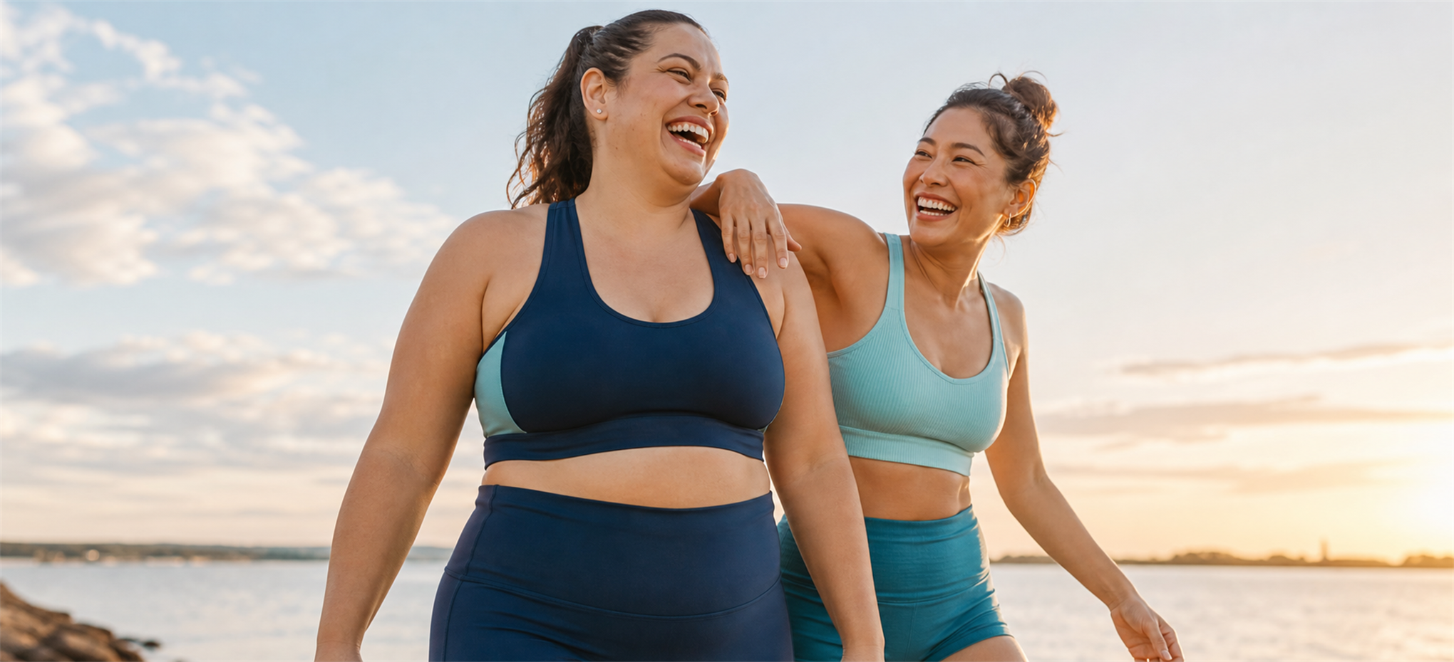 Two adults laughing together outdoors in activewear